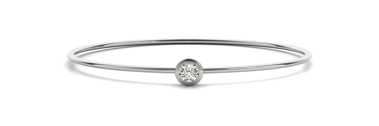 A minimalist white gold bracelet with a single round diamond set in the center, displayed on a plain white background. The design is elegant and modern.