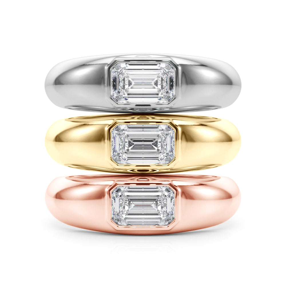 A gold ring with a rectangular, emerald-cut diamond set in the center. The ring is displayed against a plain white background, conveying elegance and simplicity.