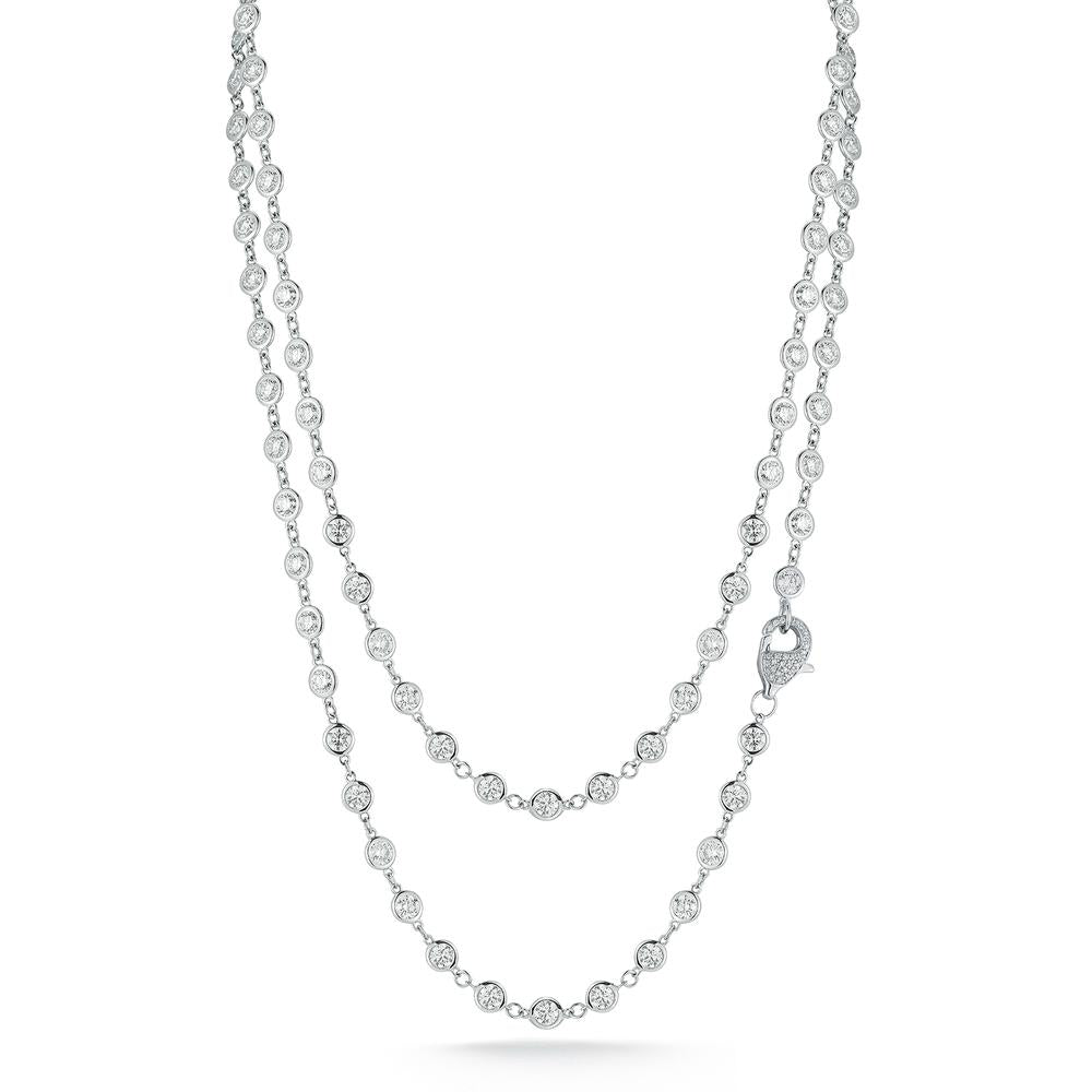 Double-layered white gold chain necklace with round bezel diamonds and pave clasp on a white background. Elegant and reflective, it conveys a sense of luxury and style.