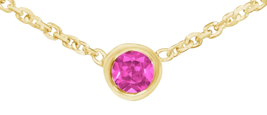 A gold chain necklace with a delicate design, featuring a single round pink pendant at the center, set against a plain white background.