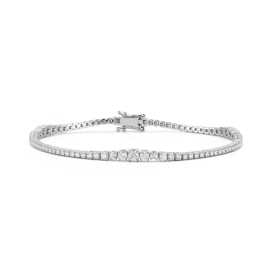 A sleek white gold tennis bracelet with sparkling round diamonds set in a continuous line, displayed on a white background, conveys elegance and luxury.