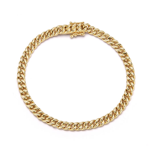 A gold chain curb link bracelet with a polished and intertwined design forms a perfect circle against a white background, conveying elegance and sophistication.