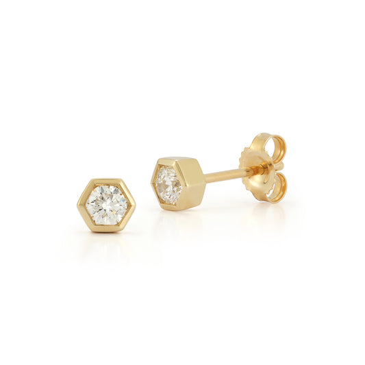Two hexagonal gold stud earrings with sparkling diamonds. The setting is sleek and modern, conveying elegance and luxury against a white background.